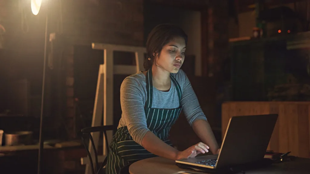 Publicidad online para pequeñas empresas: emprendedora analizando sus campañas en el portátil